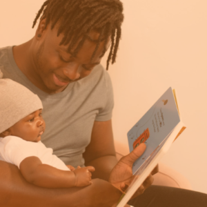 Dad holding newborn while reading a story