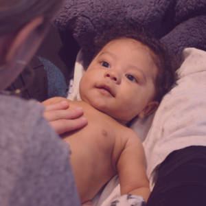 Baby looks up at mom during infant massage