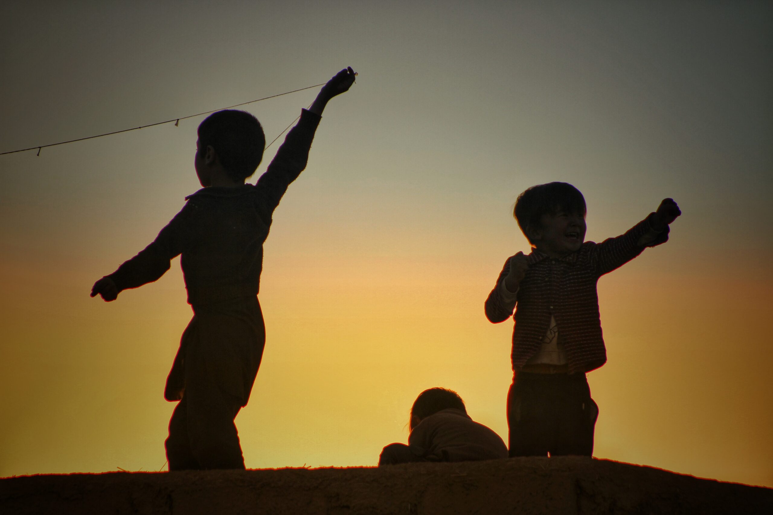Children playing in the park, sunset background.