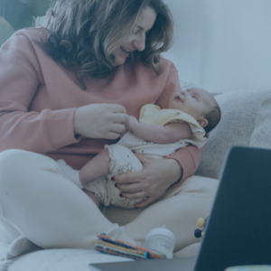 Mom holding baby while using a laptop